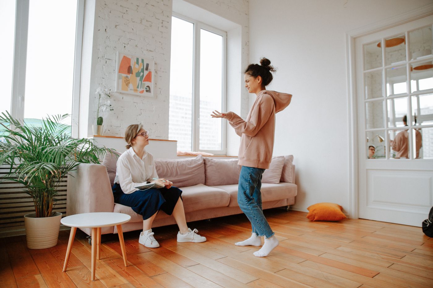 Photograph of a therapist speaking with a client in a bright, comfortable counseling room