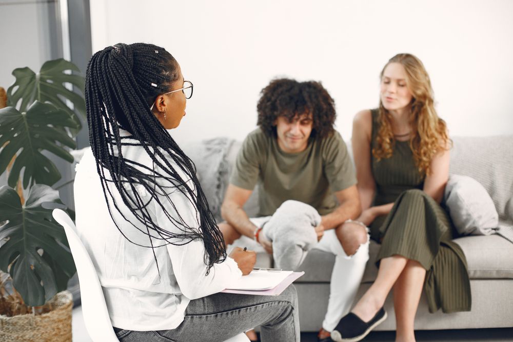 A couple speaking with a counselor in a therapy office